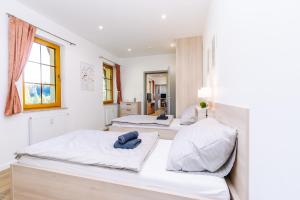 three beds in a room with white walls at Apartmán Hugo Blatná in Horní Blatná