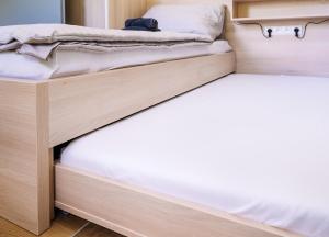 two beds in a dorm room with white sheets at Apartmán Hugo Blatná in Horní Blatná