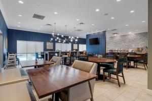 Best Western Plus St. Louis Airport Hotel في سانت لويس: مطعم بطاولات وكراسي وبار