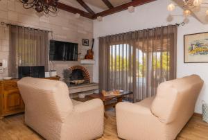 a living room with two chairs and a fireplace at Villa Anabella in Supetar