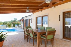 a dining room with a wooden table and chairs at Villa Anabella in Supetar