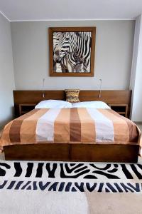 a bedroom with a bed with a zebra painting on the wall at Afrika Hotel Frýdek-Místek in Frýdek-Místek