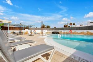 - une piscine avec des chaises longues à côté de la piscine dans l'établissement Mar Azul Corralejo- Adults Only, à Corralejo