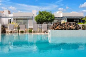 une maison avec une piscine en face d'une maison dans l'établissement Mar Azul Corralejo- Adults Only, à Corralejo