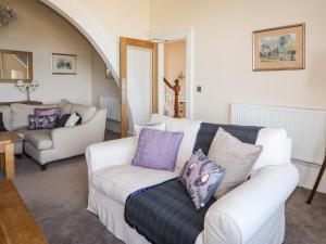 a living room with a white couch and purple pillows at Bryn Ogwen in Bangor