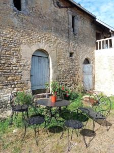 stół i krzesła przed ceglanym budynkiem w obiekcie Maris Domus près des plages du débarquement w mieście Bayeux