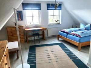 - une chambre avec un lit, un bureau et des fenêtres dans l'établissement Strandbummelhaus, à Warnemünde