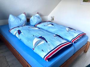 - un lit avec une couette et des oreillers bleus dans l'établissement Strandbummelhaus, à Warnemünde