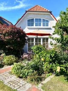 une maison avec un parasol dans la cour avant dans l'établissement Strandbummelhaus, à Warnemünde