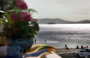 un gruppo di persone su una spiaggia vicino all'acqua di Ilion Hotel a Naxos Chora