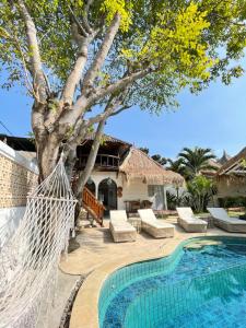 un complejo con un árbol y una piscina en Gili Breeze Tropical Bungalows, en Gili Trawangan