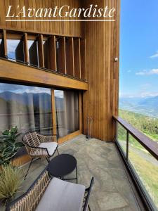 a balcony with a table and chairs on a building at L'AvantGardiste, Spacious 6 bedroom panoramic view in Crans-Montana