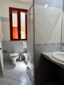 bagno bianco con servizi igienici e lavandino di Summer Breeze Apartment - Avola ad Avola