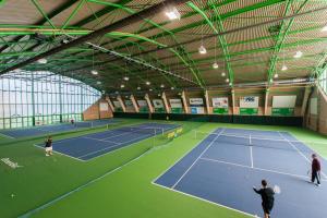 una pista de tenis con 2 personas jugando al tenis en Hotel Gem, en Wroclaw