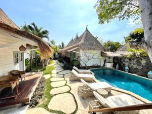 un patio trasero con piscina y una casa en Gili Breeze Tropical Bungalows, en Gili Trawangan