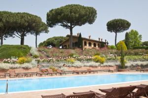 a swimming pool with a garden and a house in the background at Tenuta Cusmano in Grottaferrata