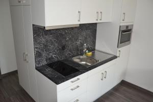 a kitchen with white cabinets and a sink at INSIDE Five in Zürich