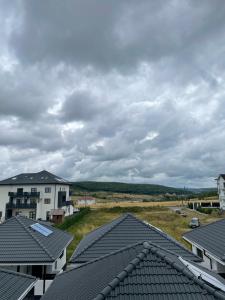 einen Blick auf die Dächer von Häusern unter einem wolkigen Himmel in der Unterkunft Apartament Mara in Baile Felix