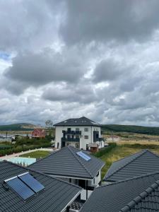 Blick auf ein Haus mit Sonnenkollektoren auf den Dächern in der Unterkunft Apartament Mara in Baile Felix