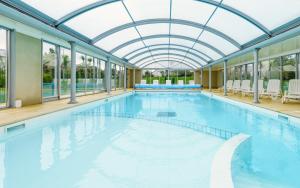 a large swimming pool with a glass ceiling at Lagrange Vacances Le Hameau De Peemor Pen in Crozon