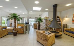 a lobby with a fireplace and tables and chairs at Lagrange Vacances Le Hameau De Peemor Pen in Crozon