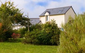 a white house with a black roof and some bushes at Lagrange Vacances Le Hameau De Peemor Pen in Crozon