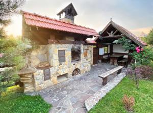 um edifício de pedra com um banco à frente em Villa Zoryany Dvir em Skhidnitsa