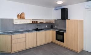 a kitchen with wooden cabinets and a sink and a stove at Rivus Apartments in Omiš