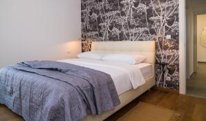 a bedroom with a bed and a black and white wall at Rivus Apartments in Omiš