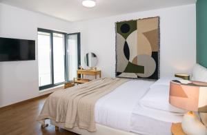 a white bedroom with a large bed and windows at Rivus Apartments in Omiš