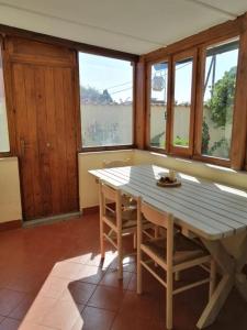 a table and chairs in a room with windows at Lo Chalet in Ponte Galeria