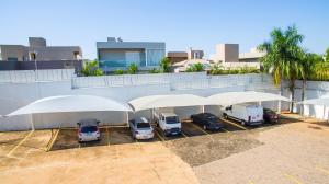 een groep auto's geparkeerd op een parkeerplaats met parasols bij Ville Hotel Gramadão in Votuporanga