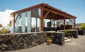 a building with a stone wall and a pavilion at Finca Isolina Hotel Boutique - Adults Recommended in Mácher