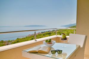 un tavolo con libri e un cesto di frutta sul balcone di Hotel Laurus - Liburnia a Opatija