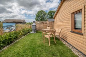 einen Tisch und Stühle im Hinterhof eines Hauses in der Unterkunft Osada Trzy Siostry in Pobierowo