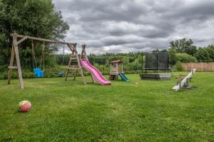 einen Spielplatz mit Rutsche und Schaukel in der Unterkunft Osada Trzy Siostry in Pobierowo