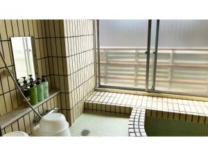 La salle de bains carrelée est pourvue d'une douche et de toilettes. dans l'établissement Kagetsu Ryokan - Vacation STAY 04880v, à Shizuoka