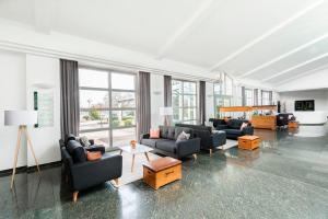 a large living room with couches and tables and windows at Hotel Akazienhaus in Herzogenaurach