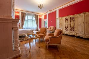 een slaapkamer met rode muren en een bed en stoelen bij Clasic Haus Sighisoara in Sighişoara