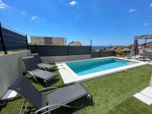 - une piscine avec 2 chaises et une table dans l'établissement Villa Fortuna, à Podstrana