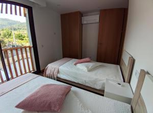 Cet appartement comprend une chambre avec deux lits et un balcon. dans l'établissement Casa João Eusébio 2, à Ponte de Lima