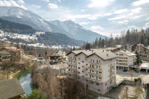 a city with a river and mountains in the background at Romatika 2 in Fiesch