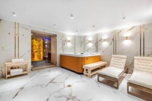 uma sala de vestir com uma banheira e 2 cadeiras em Bulwar Residence & Wellness em Kazimierz Dolny