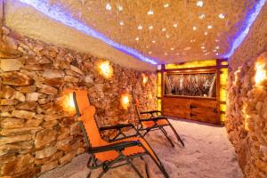 duas cadeiras num quarto com uma parede de pedra em Bulwar Residence & Wellness em Kazimierz Dolny