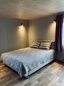 1 dormitorio con 1 cama con techo de madera en Lotes apartamenti, en Kuldīga