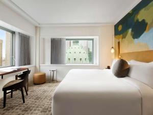 Cette chambre comprend un grand lit et un bureau. dans l'établissement Fairmont The Queen Elizabeth, à Montréal