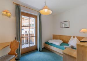 a bedroom with a bed and a window at Garni Ziernheld in Malles Venosta