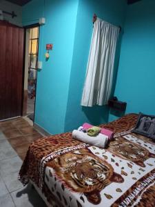 twee bedden in een kamer met een blauwe muur bij La casita de abu! in Salta