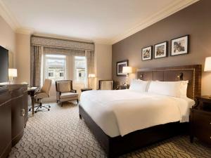 ein Hotelzimmer mit einem großen Bett und einem Schreibtisch in der Unterkunft Fairmont Chateau Laurier in Ottawa