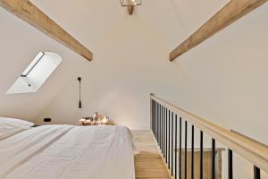 a bedroom with white walls and wooden beams at Huis Potaerde, luxe villa, vakantiewoning - landhuis nabij Brussel in Merchtem